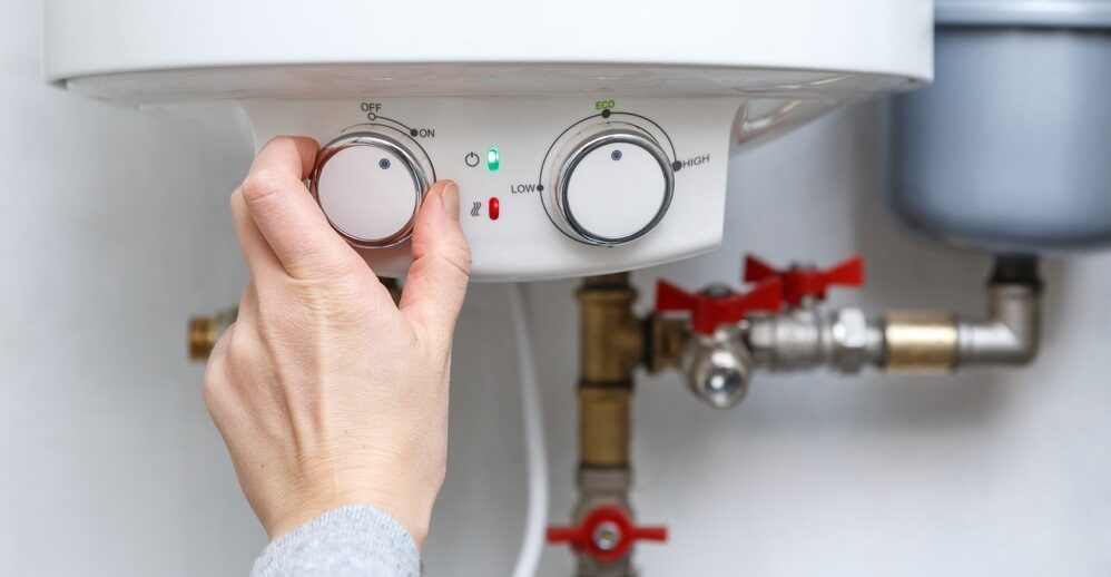 hand turning on electric water heater