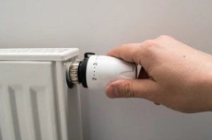 man adjusting radiator valves