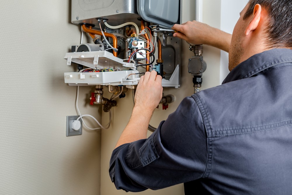 man servicing boiler