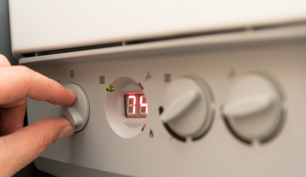 man turning on a British Combi Gas Boiler