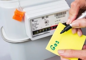 man writing gas on sticky note