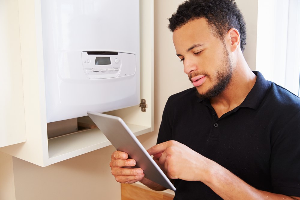 person inspecting boiler with tab