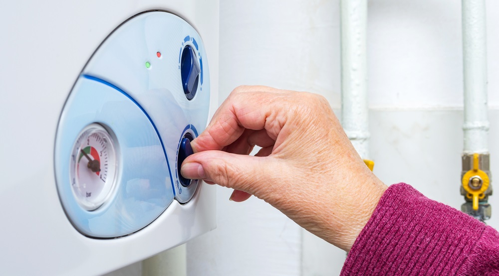 woman adjusting her heating boiler for warming apartment